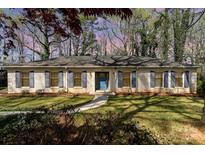 Charming one-story home featuring a brick facade, blue shutters, a well-manicured lawn, and a welcoming blue front door at 800 River Oaks Ln, Charlotte, NC 28226
