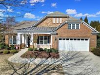 Charming brick home with a stone facade, manicured landscaping, and a two-car garage at 9332 Whistling Straits Dr, Fort Mill, SC 29707