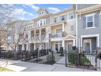 Charming townhome with a combination of stone and siding and a lovely fenced front yard and sidewalk at 234 Iverson Way, Charlotte, NC 28203