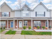 Charming brick townhome featuring manicured landscaping and inviting front porches at 331 Wilkes Place Dr, Fort Mill, SC 29715