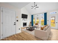 Bright living room features a fireplace, large windows, and vaulted ceilings at 10211 Ridgewell Ct, Charlotte, NC 28215