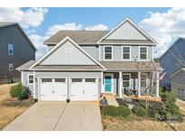 Charming two-story home with attached two-car garage, covered porch, and manicured landscaping at 1426 Whitman Ct, York, SC 29745