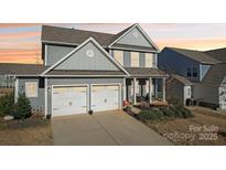 Charming gray two-story home with a two-car garage, inviting front porch, and well-maintained landscaping at 1426 Whitman Ct, York, SC 29745