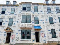 View of new construction townhome with Barricade wrap, dormer windows, and covered entryway at 15332 Ballancroft Pkwy # 17, Charlotte, NC 28277