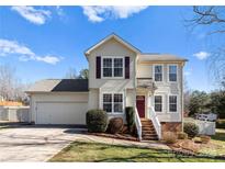 Charming two-story home features a well-maintained lawn and a welcoming front entrance with a red door at 159 Creekwood Dr, Mooresville, NC 28117