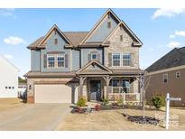 Beautiful two-story home featuring a stone facade, large windows, and a well-manicured front yard at 172 Tetcott St, Mooresville, NC 28115