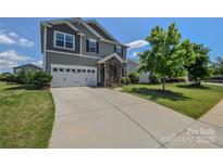 Charming two-story home featuring a two-car garage and stone-accented entryway on a lush lawn at 173 Glastonbury Dr, Mooresville, NC 28115