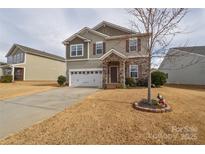 Charming two-story home with stone accents, well-manicured lawn, and two car garage at 173 Glastonbury Dr, Mooresville, NC 28115