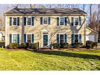 Charming two-story home with manicured lawn, complemented by beautiful trees and vibrant green shutters at 1919 Windlock Dr, Charlotte, NC 28270