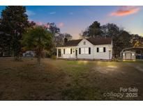 Charming single-Gathering home with a welcoming front porch and well-maintained lawn at dusk at 308 Knox St, Clover, SC 29710