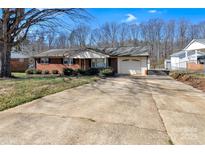 Charming single-story brick home with a long driveway and attached one car garage at 4233 Dawnwood Dr, Gastonia, NC 28056