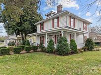Charming two-story home with a well-manicured lawn, mature trees, and a welcoming front porch at 629 S Fulton St, Salisbury, NC 28144