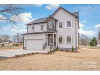 Beautiful two-story home featuring a two-car garage, stone accents, manicured landscaping, and a welcoming front entrance at 6535 Fisher Farm Nw Ln, Concord, NC 28027