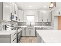 Modern kitchen featuring stainless steel appliances, granite countertops, shaker cabinets, and subway tile backsplash at 6535 Fisher Farm Nw Ln, Concord, NC 28027