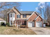 Charming two-story home featuring a brick facade, a two-car garage, and a well-manicured lawn at 8430 Forest Shadow Cir, Cornelius, NC 28031