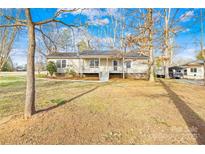 Charming single-story home with a front porch, mature trees, and well-maintained landscaping at 120 Roger Dr, Statesville, NC 28625