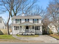Charming two-story white home with black shutters and a welcoming front porch with a decorative railing at 2028 Scott Ave, Charlotte, NC 28203