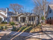 Charming bungalow-style home with craftsman details and mature trees on a sunny day at 2112 Floral Ave, Charlotte, NC 28203