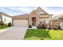 Charming single-Gathering home showcasing a manicured lawn, brick accents, and an attached two-car garage at 3532 Tully Ave, Kannapolis, NC 28081