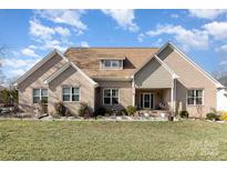 Charming brick home featuring a well-manicured lawn, inviting front porch, and an array of decorative shrubbery at 4321 Rolling Acres Rd, Charlotte, NC 28213