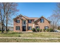 Charming brick two-story home featuring a well-manicured lawn and black shutters at 5000 Tulip Ln, Matthews, NC 28104
