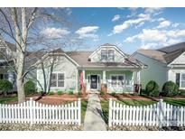 Charming one-story home with a welcoming front porch, a white picket fence, and beautiful landscaping at 7037 Ladys Secret Dr, Indian Trail, NC 28079