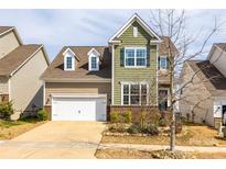 Inviting two-story home featuring a well-manicured lawn, attached garage, and charming architectural details at 844 Braddock Way, Fort Mill, SC 29715