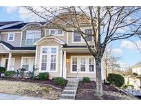 Charming townhome featuring neutral siding, multi-pane windows, and a welcoming front entrance at 9741 Turning Wheel Dr, Charlotte, NC 28214