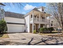 Charming two-story home featuring a double porch, stone accents, a two-car garage and mature trees at 13014 Windy Lea Ln, Huntersville, NC 28078
