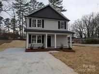 Charming two-story home with gray siding, black shutters, a new concrete driveway, and a well-maintained lawn at 1302 Browdis Ave, Kannapolis, NC 28083