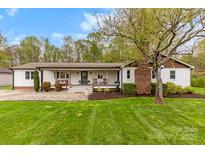 Charming ranch-style home with a cozy front porch and well-manicured lawn at 1335 Blacksnake Rd, Stanley, NC 28164