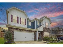 Charming two-story home featuring a brick facade, white siding, red shutters, and a convenient two-car garage at 15119 Oleander Dr, Charlotte, NC 28278