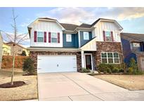 Charming two-story home with a stone facade, red shutters, attached garage, and well-maintained landscaping at 15119 Oleander Dr, Charlotte, NC 28278