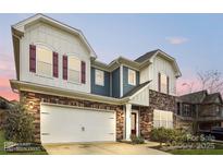 Charming two-story home boasts a stone facade, neutral siding, red shutters, and a spacious two-car garage at 15119 Oleander Dr, Charlotte, NC 28278