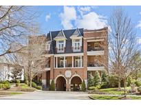 Elegant brick building with arched entryway and balconies, set against a bright sky at 2251 Selwyn Ave # 201, Charlotte, NC 28207
