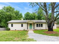 Charming single-story brick home with a well-maintained front yard, gravel driveway, and a lovely, light green front door at 228 Tot Dellinger Rd, Cherryville, NC 28021
