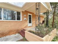 Inviting front porch of brick home with tasteful landscaping and charming architectural details at 2548 Milton Ave, Gastonia, NC 28052