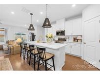 Bright, updated kitchen with island, modern appliances, white cabinets, and hardwood floors at 3512 Auburn Curb Rd, Charlotte, NC 28217