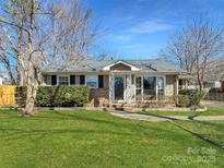 Inviting home with tidy front yard, mature shrubs, and a charming front porch, creating a warm and welcoming atmosphere at 4201 Winedale Ln, Charlotte, NC 28205
