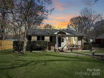 Charming single-story home with a well-manicured front lawn and a welcoming porch, perfect for enjoying peaceful evenings at 4201 Winedale Ln, Charlotte, NC 28205