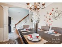 Dining room with wood table, seating for six, decorative wall art, and chandelier at 558 Rough Hewn Ln, Rock Hill, SC 29730