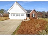 Charming single-story home with brick and white siding and an attached garage at 807 Limerick Dr, Dallas, NC 28034