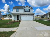Charming two-story home with stone accents, a two-car garage, and a well-manicured lawn at 107 Adams Tree Way, Troutman, NC 28166