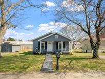 Charming home featuring a well-manicured lawn and inviting front porch with a swing at 125 Ashe St, Gastonia, NC 28056