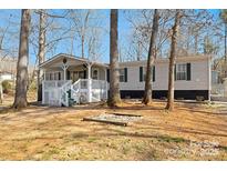 Charming manufactured home with a cozy porch and landscaped front yard for relaxed outdoor living at 140 Sanford Ln, New London, NC 28127