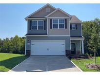 Charming two-story home featuring a two car garage, neutral siding and trim, and a well manicured lawn at 1544 Doran Ter, Richburg, SC 29729