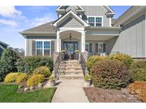 Charming home featuring a welcoming front entrance, stone steps, and lush landscaping at 190 Hidden Meadows Dr, Mooresville, NC 28117