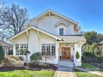 Charming white two-story home with a brick chimney, manicured landscaping and a walkway to the front door at 2004 Lombardy Cir, Charlotte, NC 28203