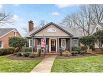 Charming home featuring a quaint front porch with rocking chairs and an American flag at 2009 Charlotte Dr, Charlotte, NC 28203