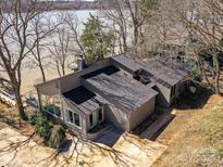 Attractive single-story home featuring large windows and a dark roof located on a waterfront lot with mature trees at 3030 Point Clear Dr, Tega Cay, SC 29708